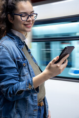 Pretty young girl looking at her phone in the train station