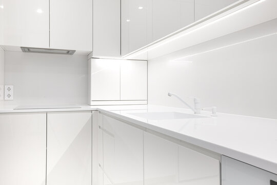 Modern snow white kitchen interior with acrylic countertop