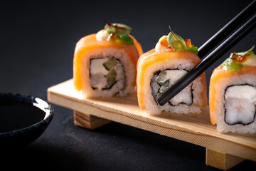 Japanese cuisine. Sushi rolls on a black platter