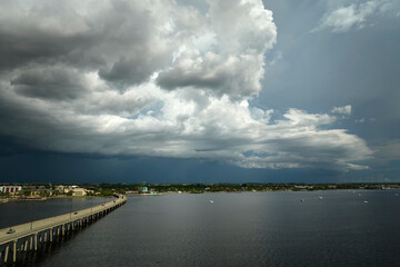 Heavy thunderstorm approaching traffic bridge connecting Punta Gorda and Port Charlotte over Peace River. Bad weather conditions for driving during rainy season in Florida