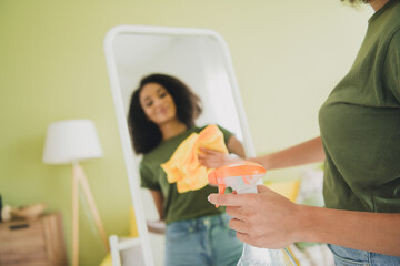 Fototapeta premium Photo of nice young girl cleaning mirror reflection wear green clothes modern daylight cozy interior flat indoors