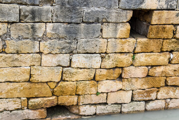 old stone roman wall with two air holes in the city of tarragona, spain