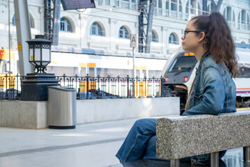 Young girl waiting for the train at a large European station