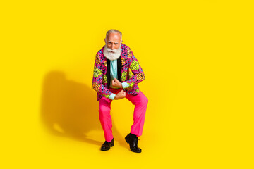 Full length photo of attractive retired man powerful show muscles dressed colorful pink fancy clothes isolated on yellow color background