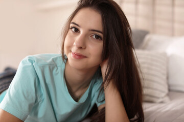 Portrait of teenage girl on bed at home