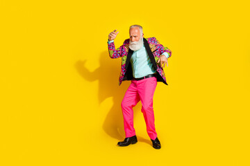 Full length photo of attractive retired man point empty space dressed stylish colorful pink fancy clothes isolated on yellow color background