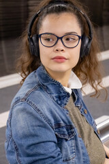 Girl with headphones enjoys music while waiting for public transport