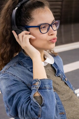 Girl with headphones enjoys music while waiting for public transport