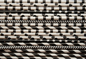 Fun black and white paper straws placed on a wooden surface.