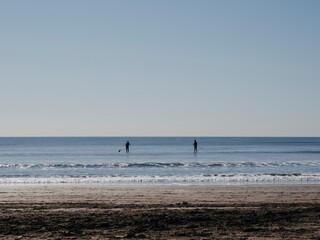 Dos personas practicando Stand Up Paddle en el mar
