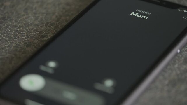 Incoming call from Mom on smartphone macro video.