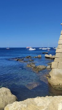Stone wall overlooking boats sailing on tabarca island