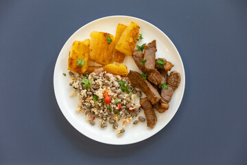 Traditional rustic tropical Brazilian dish, sun-dried beef with green beans, cassava, biquinho pepper. Creative rustic photography