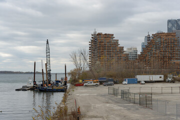 Naklejka premium view from Cherry Street North Bridge to rigging and construction of condos (Aqualuna Condos) with overcast sky in Toronto, Canada