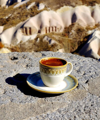 A cup of Turkish coffee with a view to the Cappadocia landscape.
