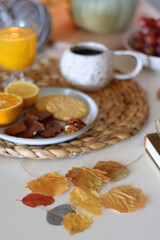 Pumpkins, various food and drinks, fall decorations, books and candles on the table. Fall hygge at home. Selective focus.