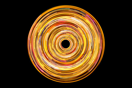 Neon circle lines with empty copy space isolated on black background. Colorful led lights long exposure rotation photo. Eco shiny light glow. Cosmos space planet abstraction. Yellow red vortex spiral.