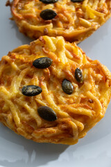Pumpkin grated roasted patties, rosti or latkes, made fron squash and potato decorated with pumpkin seeds