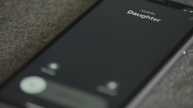 Incoming call from Daughter on smartphone macro video.