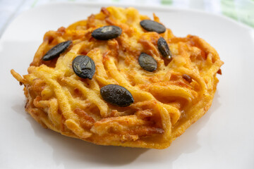Pumpkin grated roasted patties, rosti or latkes, made fron squash and potato decorated with pumpkin seeds