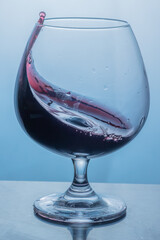 Red wine splashes in the glass 