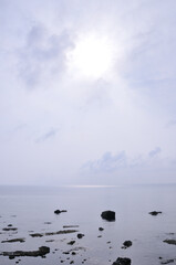 Clouds floating on the sea on a cloudy day and sunlight pouring in vertical /...