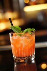 Watermelon Mint Punch Refreshing orange cocktail with mint leaves on a bar counter
