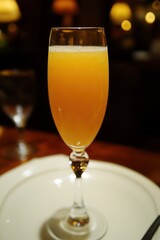 Grapefruit Mimosa Elegant bellini cocktail in a champagne flute on a restaurant table setting