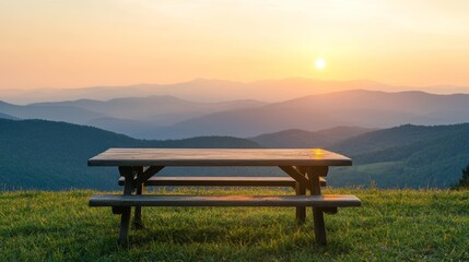 Obraz premium A serene picnic table overlooks rolling hills as the sun sets, casting a warm glow over the landscape, creating a tranquil outdoor scene.
