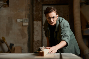 A dedicated carpenter skillfully works on wood surfaces in a vibrant workshop filled with tools and materials.