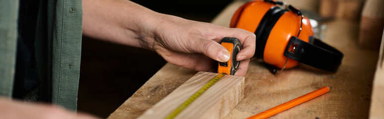 A skilled female carpenter meticulously measures wood in her vibrant workshop, ready for...