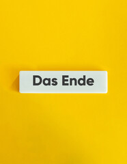 The End Word. Text on Block Letter Tile on Yellow Background. Minimal Aesthetic.