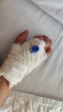 close up focus of kids hand wrapped with bandage and branula