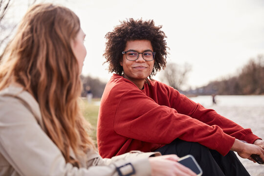 Gen Z couple outside beside a river hanging out and having fun together. Munich, Germany