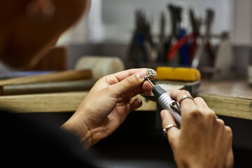 A skilled artisan finely shapes beautiful jewelry using specialized tools and techniques.