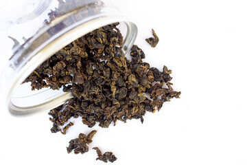 Close-up photo of a jar of herbal tea spilled on a white background. Green tea strengthens the immune system by protecting it against oxidants and radicals, thereby reducing the risk of infections.