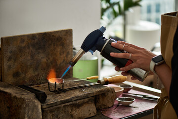 A talented craftsman shapes metal with a torch, showcasing artistry and craftsmanship in the studio.