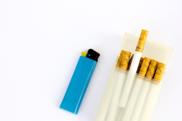 A pack of cigarettes and a blue lighter isolated on white background. Cigarette smoking is a major risk factor for heart disease and stroke. 