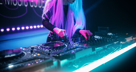 Talented Female Artist Performing a DJ Set on Turntables Live on Stage. Young Beautiful Woman...