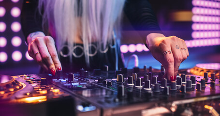 Female DJ Performing Live on Stage, Mixing Tracks With Professional Equipment. Close Up Shots of...
