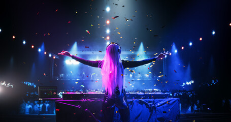 Caucasian Girl Performing at a DJ Concert Live on Stage. Talented Music Producer Dancing, Mixing Energetic Dance Hits on Turntables. Young Female Engaging with the Crowd. Back View
