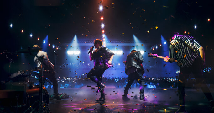 Rock Musicians in Fashionable Outfits Performing Alternative Punk Rock Music on a Nightclub Stage, Passionately Playing Guitars Under Bright Spotlights, Bringing Energy to Cheering Fans