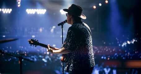 Portrait of a Handsome Young Man Singing a Country Song and Playing Guitar at a Music Festival....