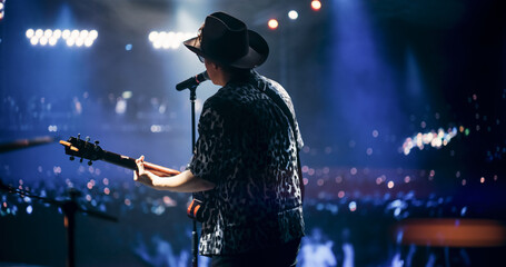 Portrait of a Handsome Young Man Singing a Country Song and Playing Guitar at a Music Festival....