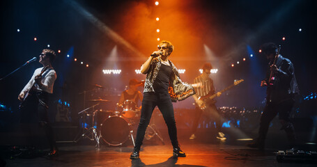 Indie Rock Band Delivers a Beautiful Live Performance With Guitars and Drums at a Modern Nightclub with Glittering Confetti. Colorful Lights and Powerful Sound at a Rock Festival