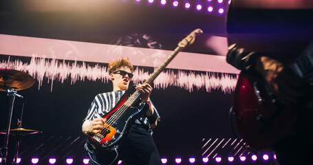 Rock Band Performing on Stage, Guitarist in a Leather Jacket and a Bandana Playing Passionately....