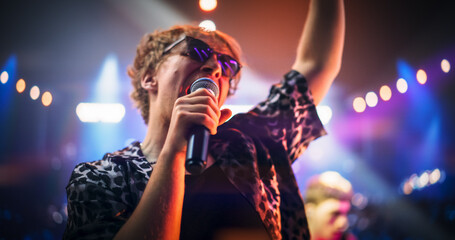 Portrait of a Male Singer, Wearing Sunglasses and a Patterned Shirt, Passionately Performs With His...