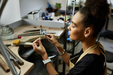 Focused artisan creates stunning jewels while surrounded by tools and materials in her workspace