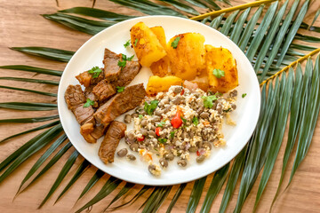 Traditional rustic tropical Brazilian dish, sun-dried beef with green beans, cassava, biquinho pepper. Creative rustic photography