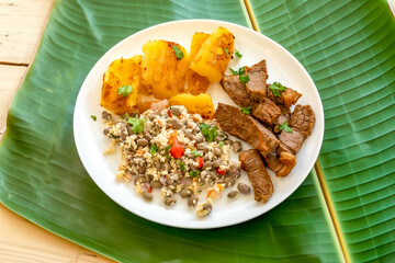 Traditional rustic tropical Brazilian dish, sun-dried beef with green beans, cassava, biquinho pepper. Creative rustic photography